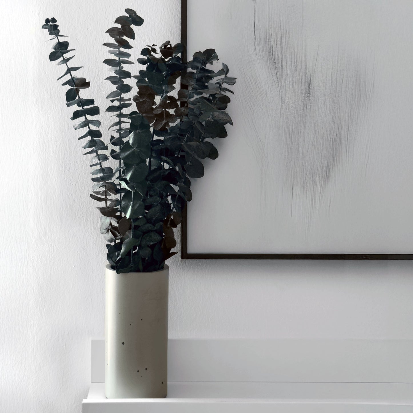 Blumenvase ALEA aus Beton auf einem Wandregal gefüllt mit Eukalyptus